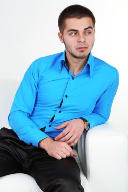 açık renkli kanepede otururken yakışıklı genç