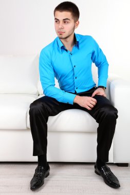 açık renkli kanepede otururken yakışıklı genç