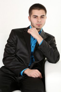 açık renkli kanepede otururken yakışıklı genç