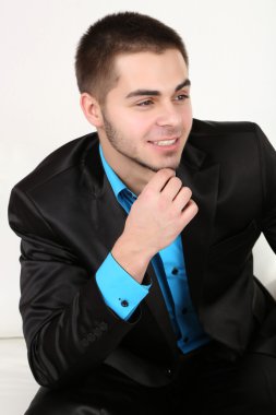 açık renkli kanepede otururken yakışıklı genç