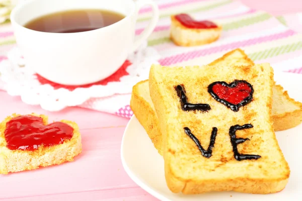 Delicious toast with jam and cup of tea on table close-up — Stock Photo, Image