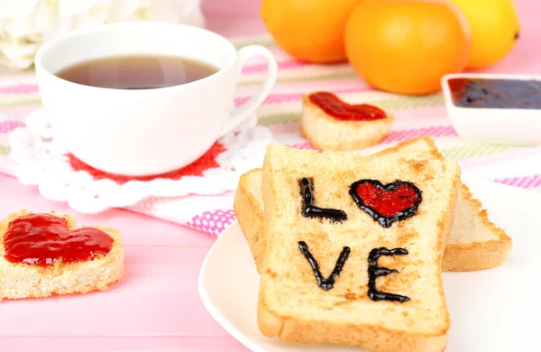 Heerlijke toast met jam en kopje thee op tabel close-up — Stockfoto