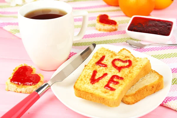 Delicioso brindis con mermelada y taza de té en primer plano de la mesa — Foto de Stock