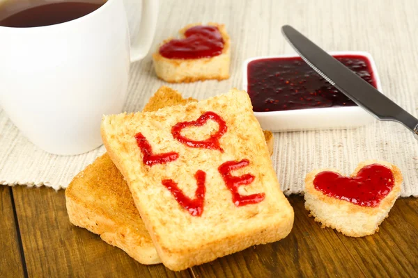 Delicious toast with jam and cup of tea on table close-up — Stock Photo, Image