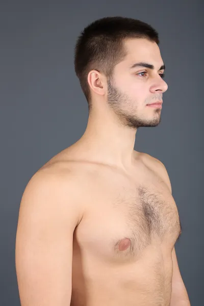 Schöner junger Mann auf grauem Hintergrund — Stockfoto