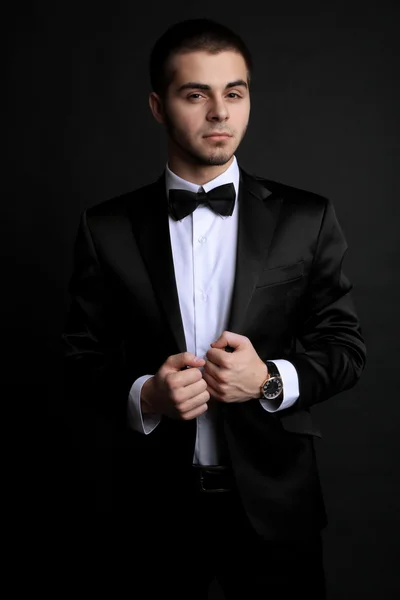 Hombre joven guapo en traje sobre fondo oscuro —  Fotos de Stock