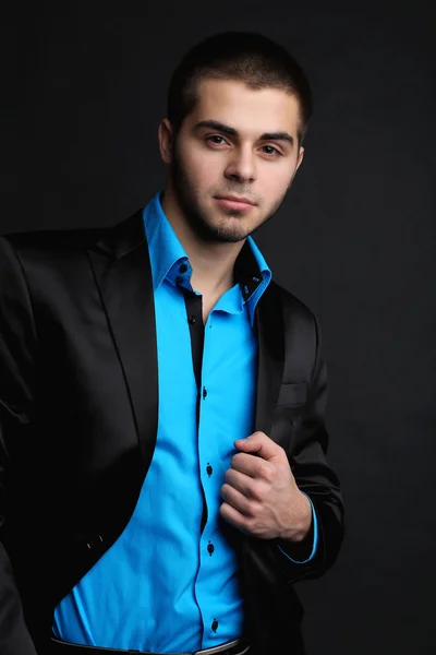 Handsome young man in suit on dark background — Stock Photo, Image