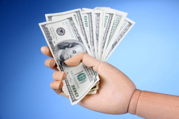 Money in wooden hand, on color background — Stock Photo, Image
