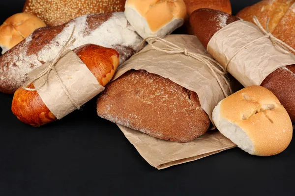 Different types of bread on black background, close-up — Stock Photo, Image