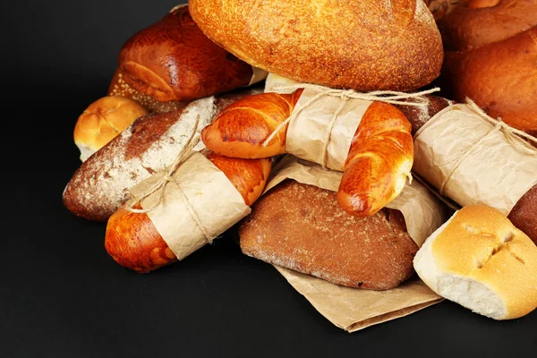 Olika typer av bröd på svart bakgrund, närbild — Stockfoto