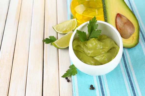 Fresh guacamole in bowl on wooden table — Stock Photo, Image