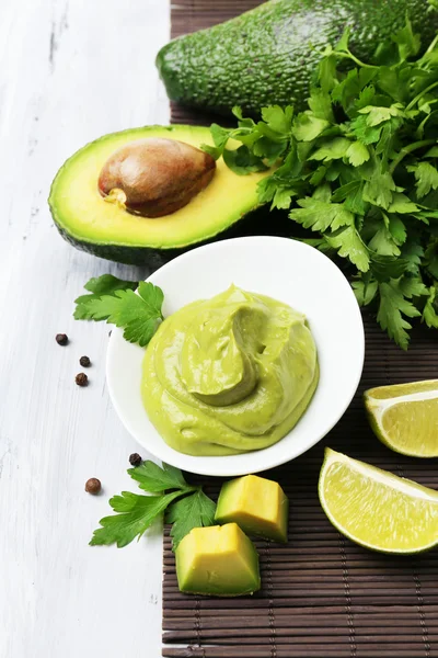 Ahşap masa üzerinde kase taze guacamole — Stok fotoğraf