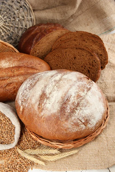 Pan de centeno con granos en la mesa sobre fondo de saco —  Fotos de Stock