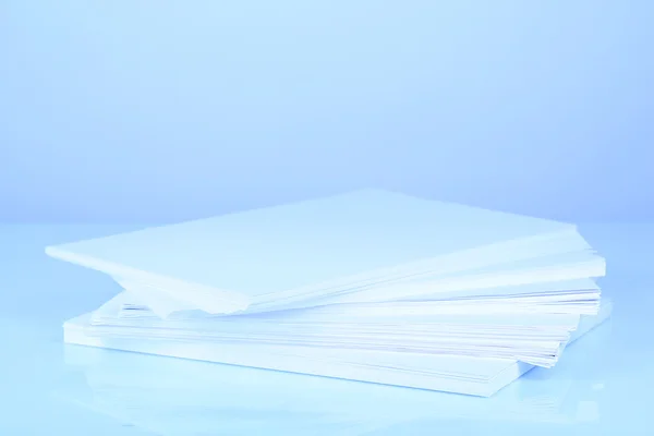 Stack white paper in blue light — Stock Photo, Image