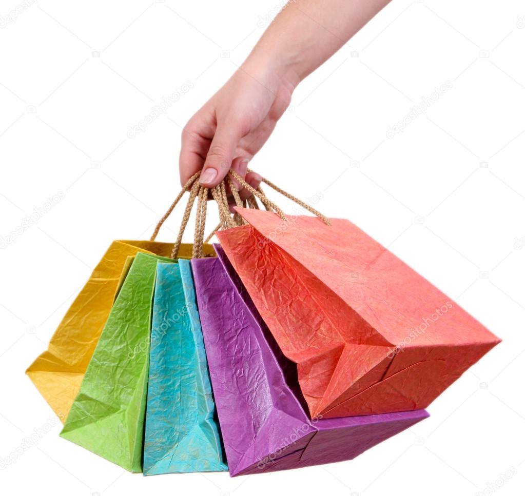 Colorful shopping bags in female hand, isolated on white