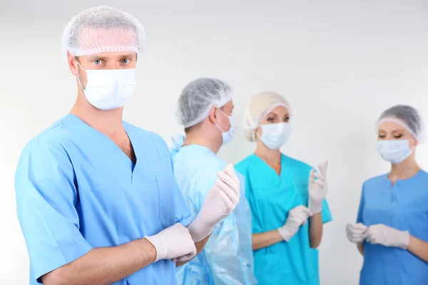Chirurgen permanent op grijze achtergrond — Stockfoto