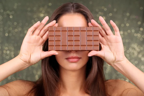 Retrato de menina bonita com chocolate no fundo brilhante — Fotografia de Stock