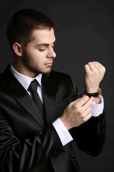 Handsome young man in suit on dark background — Stock Photo, Image