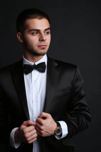 Hombre joven guapo en traje sobre fondo oscuro —  Fotos de Stock