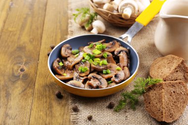 Masanın üzerinde tavada kızartılmış mantarlar.