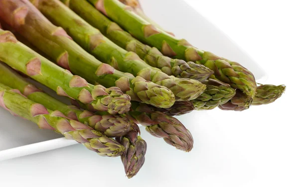 Deliciosos espárragos frescos en un plato aislado en blanco —  Fotos de Stock