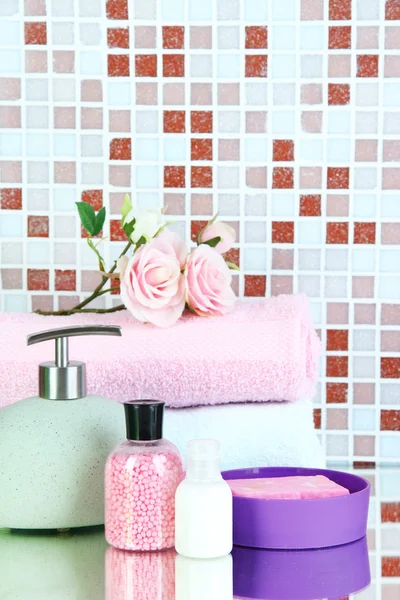 Cosmetics and bath accessories on mosaic tiles background — Stock Photo, Image