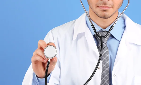 Médico masculino em pé no fundo azul — Fotografia de Stock