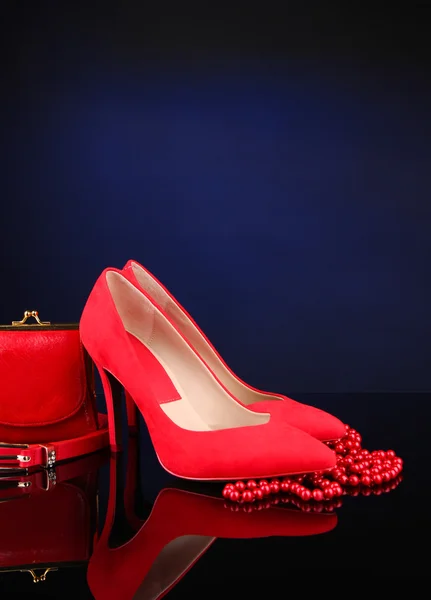 Belle scarpe rosse femminili, borsa e cintura, su sfondo blu — Foto Stock