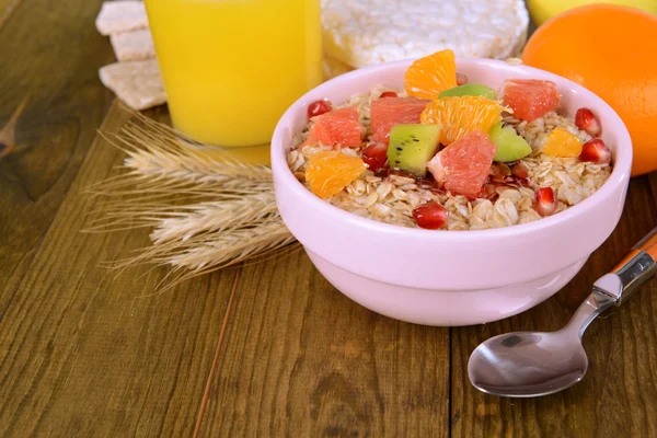 Delicious oatmeal with fruit in bowl on table close-up — Stock Photo, Image