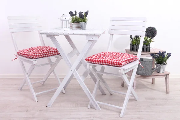 Garden chairs and table with flowers on wooden stand on white background — Stock Photo, Image