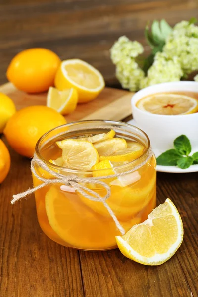 Tasty lemon jam with cup of tea on table close-up — Stock Photo, Image