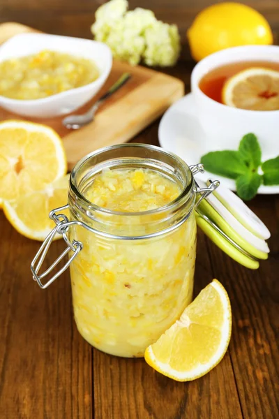 Engarrafamento de limão saboroso com xícara de chá na mesa close-up — Fotografia de Stock