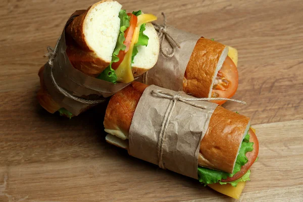 Свежий и вкусный сэндвич на деревянном фоне — стоковое фото