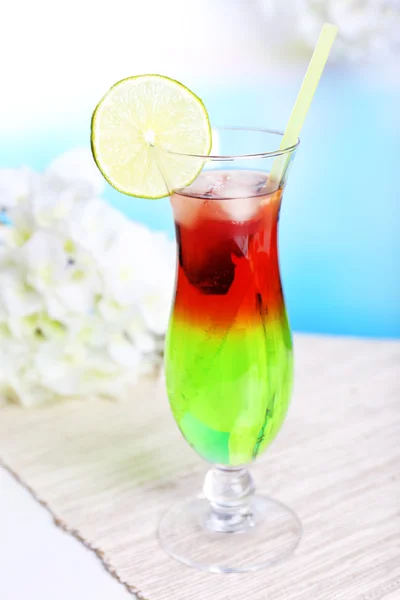 Glas Cocktail auf Tisch auf hellblauem Hintergrund — Stockfoto