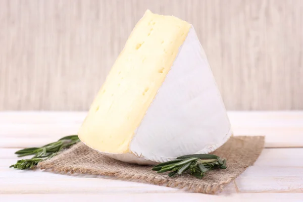 Sabroso queso Camembert con romero, sobre mesa de madera —  Fotos de Stock