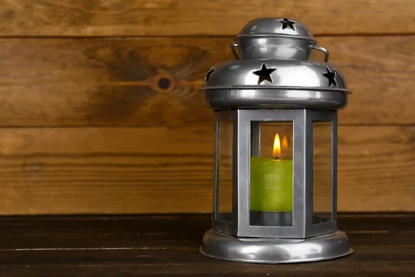 Lanterna metálica decorativa sobre fundo de madeira — Fotografia de Stock
