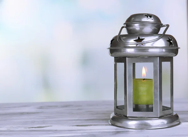 Decorative metallic lantern on wooden table on bright background — Stock Photo, Image