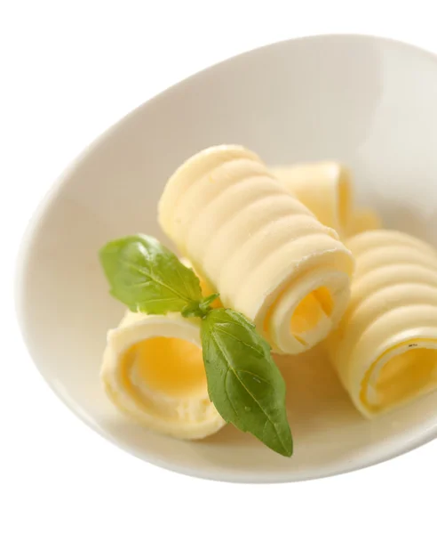 Curls of fresh butter with basil in bowl, isolated on white — Stock Photo, Image