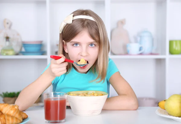 Mooi meisje ontbijt eten in keuken thuis — Stockfoto