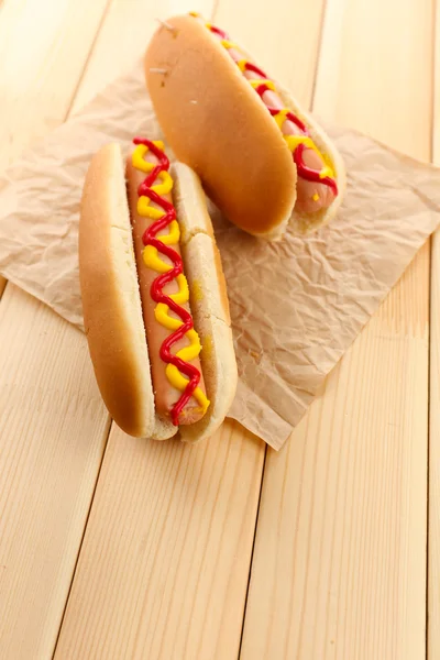 Sabrosos perritos calientes en mesa de madera — Foto de Stock