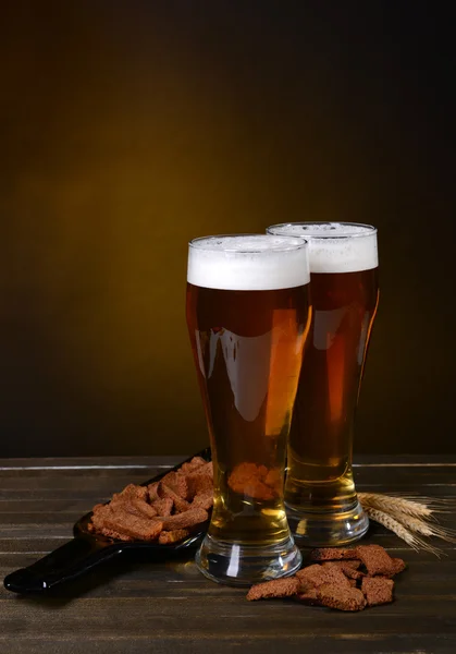 Glas öl med fika på bordet på mörk bakgrund — Stockfoto