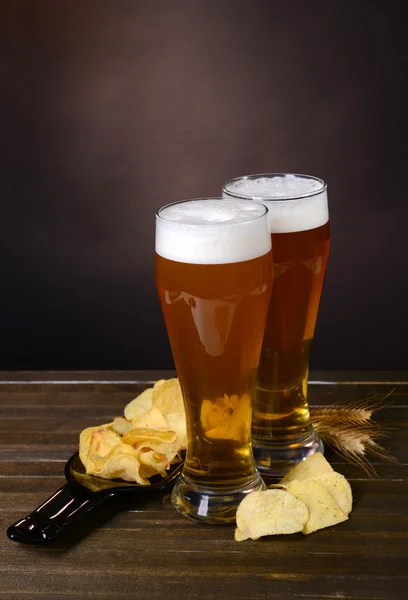 Glas öl med fika på bordet på mörk bakgrund — Stockfoto