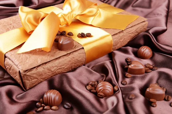 Pyszne czekoladki w polu na brązowym tle — Zdjęcie stockowe