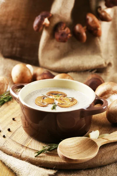 Composition with mushroom soup in pot, fresh and dried mushrooms, on wooden table, on sackcloth background — Stock Image Composition with mushroom soup in pot, fresh and dried mushrooms, on wooden table, on sackcloth background Stock Picture