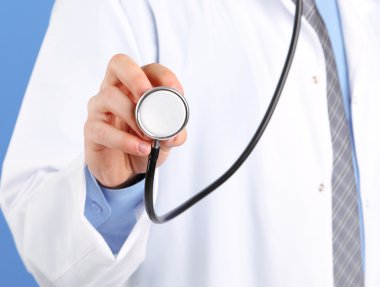 mavi arka plan üzerinde duran erkek doktor