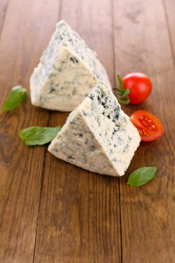 ahşap masa üstünde domates ve fesleğen ile lezzetli mavi peynir