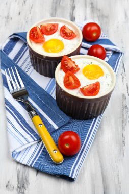 Baked eggs on wooden table close up