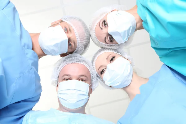 Vista desde abajo de los cirujanos en desgaste protector del trabajo durante la operación —  Fotos de Stock