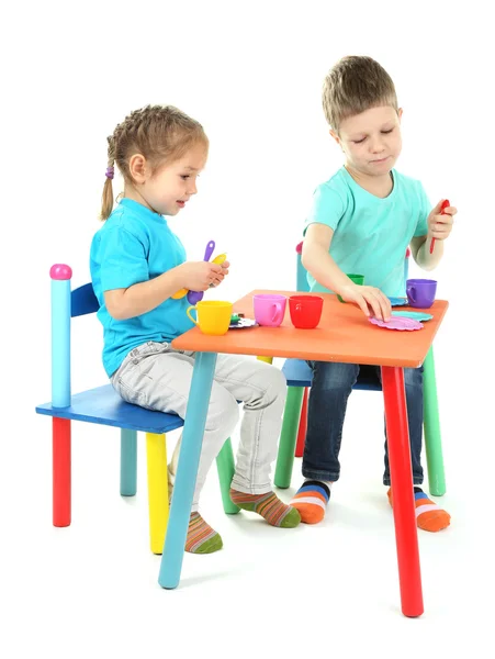 Kleine Kinder spielen mit buntem Geschirr isoliert auf weiß — Stockfoto