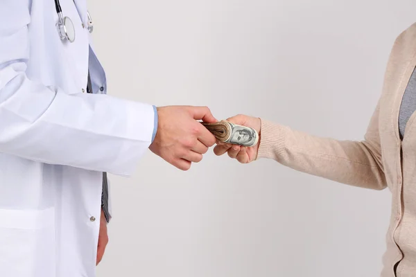 Mannelijke arts ontvangen van geld uit patiënt, geïsoleerd op wit — Stockfoto